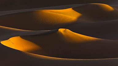 Last rays of sun on a group of dunes, Sahara, Algeria (© AWL Images/DanitaDelimont.com)