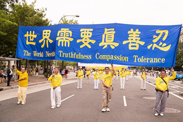 6月20日，全球部分法轮功学员聚集在美国首府华盛顿DC，举行反迫害集会游行。图为游行队伍中的“世界需要真善忍”大型横幅。（戴兵／大纪元）