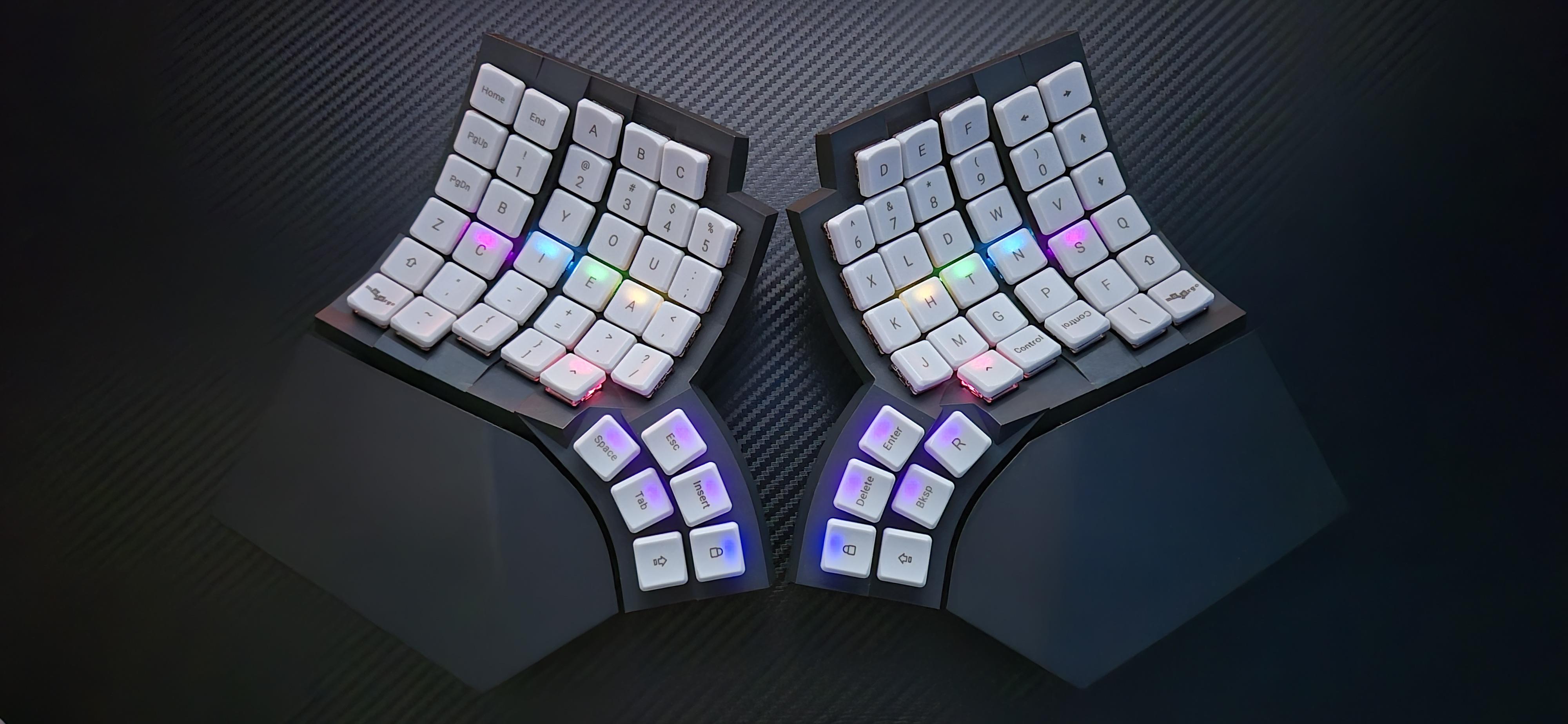 Photograph of my MoErgo Glove80 keyboard with Enthium layout and per-key RGB illumination.