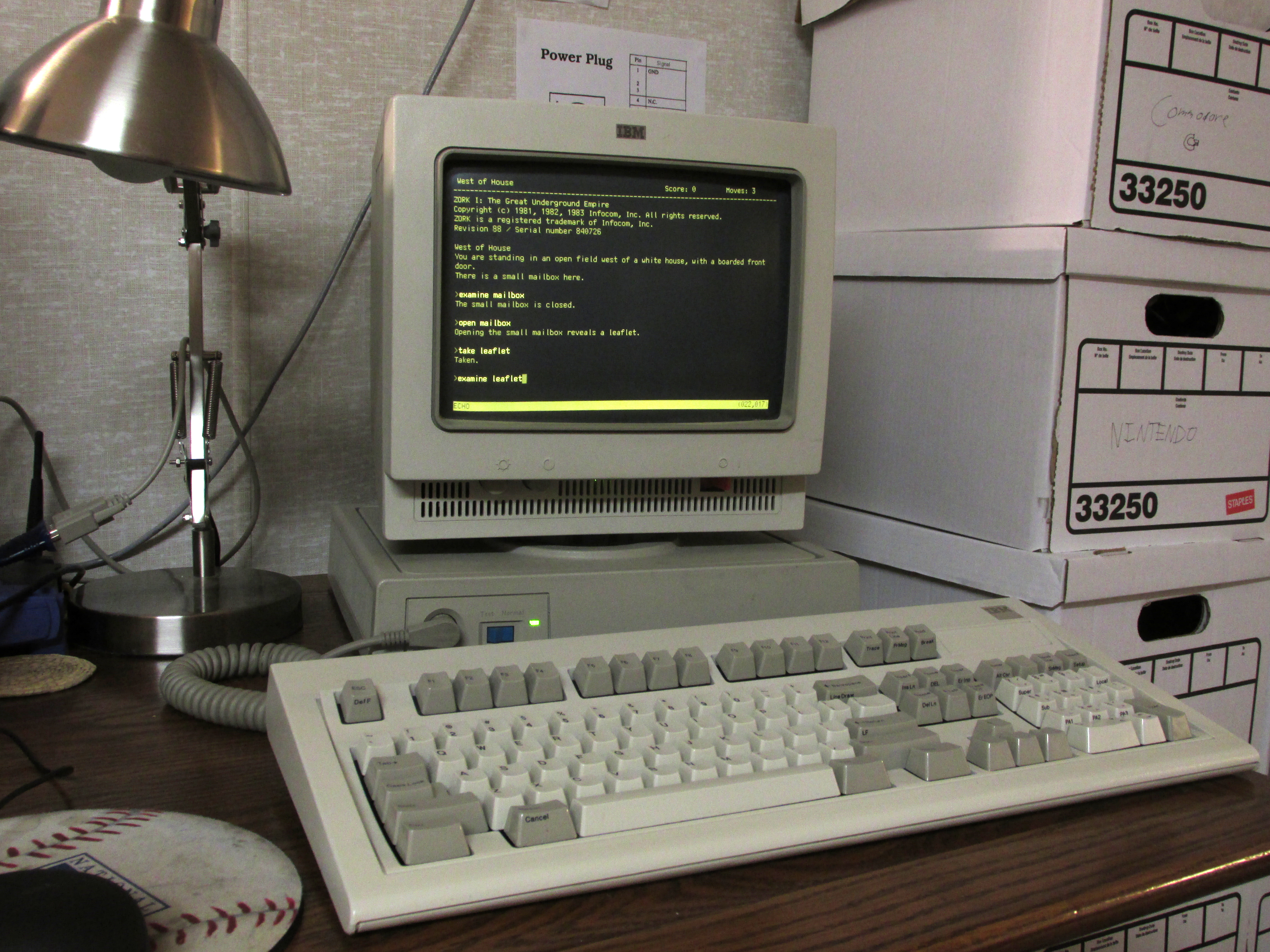 Photo of IBM 3161 terminal with amber CRT playing the text-based adventure gam e, Zork