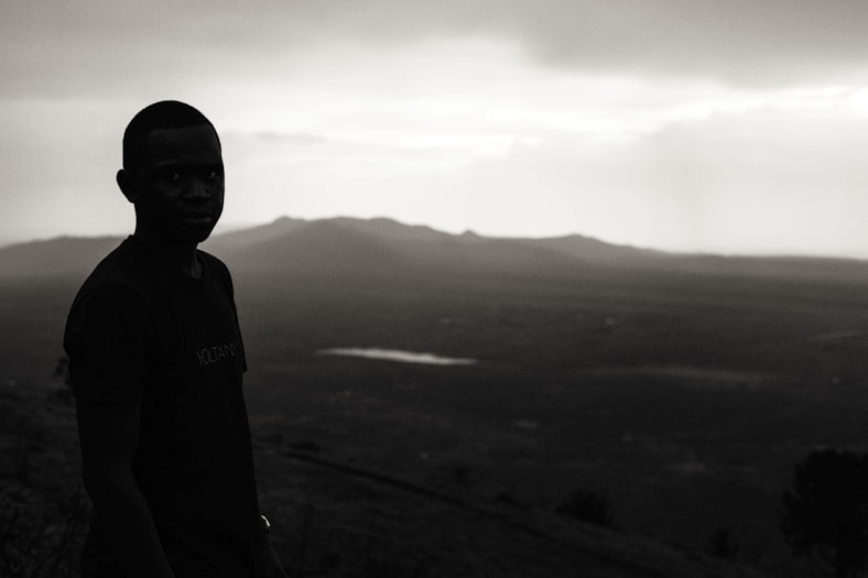 A Black boy standing on Ngong Hills during foggy day in Nairobi, Kenya.