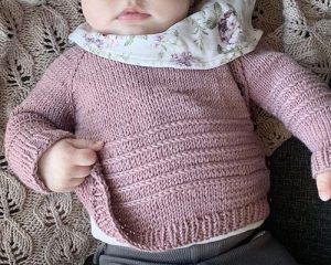 Closeup of baby waring a knittet jacket