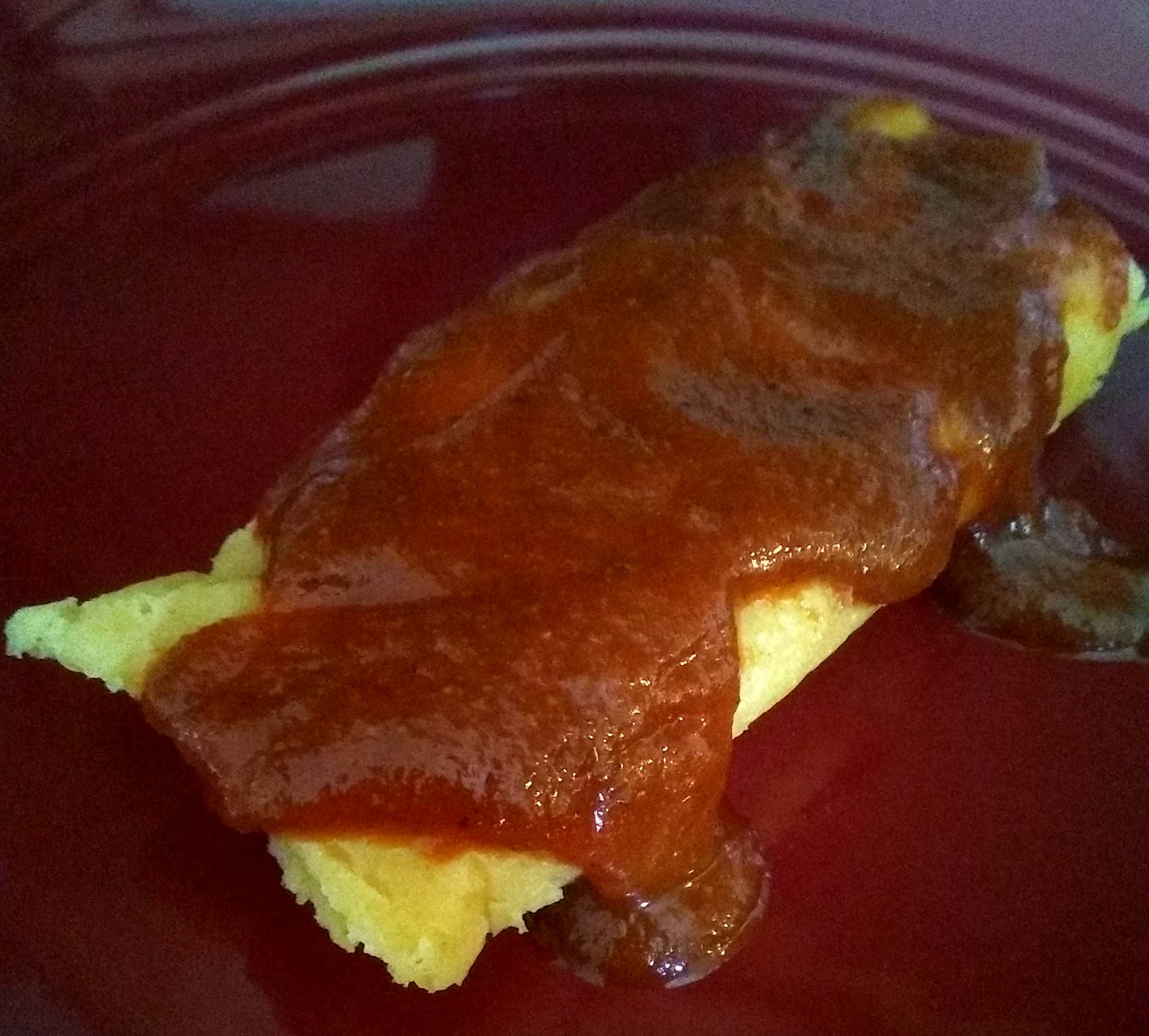 Photo of a tamale with sauce