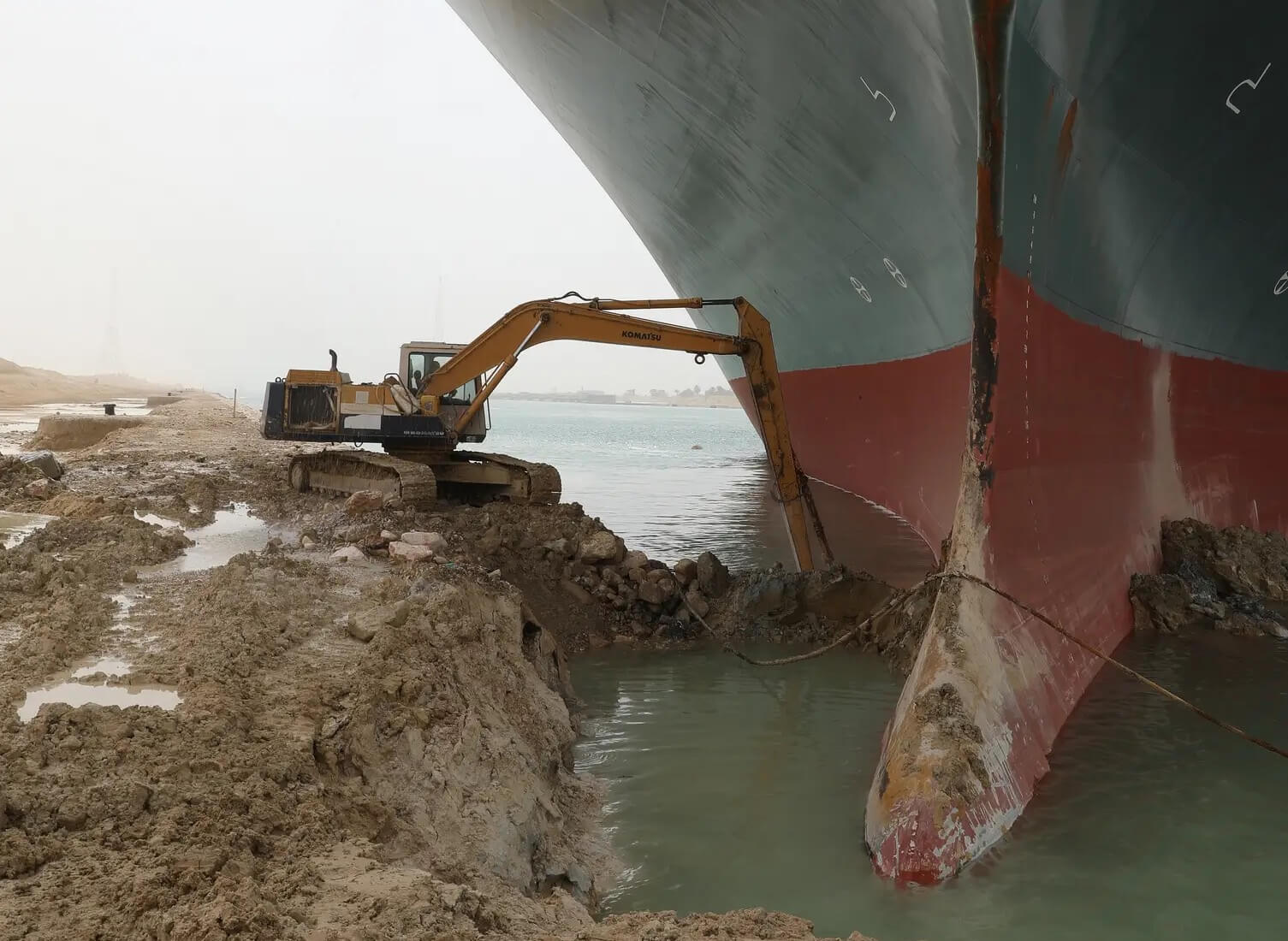 A small digger trying to move the evergreen stuck cruise ship in the suez canal