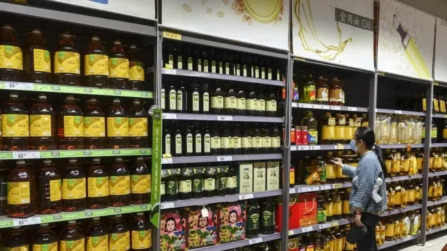 A woman shops for cooking oil at a Carrefour supermarket on March 30, 2022 in Shanghai, China. From 3 a.m. on April 1 to 3 a.m. on April 5, the regions lying to the west of the Huangpu River will be locked down while the local residents are tested for COVID-19