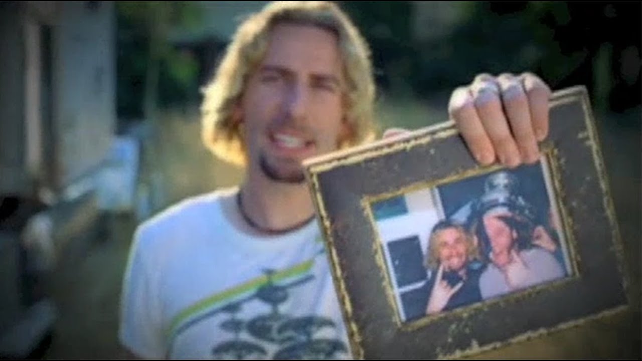 Man holding up a picture. (Screenshot from a Nickelback music video)