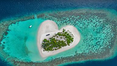 Heart-shaped island with sandy beach, offshore coral reef, Indian Ocean, Maldives (© Willyam Bradberry/Shutterstock)