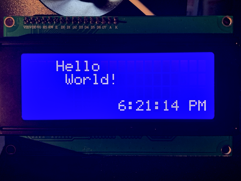 hello-world executed on an LCM2004A 4x20 character display (white text on blue background)