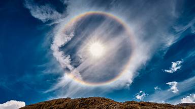 Sun halo over Lake Antermoia in the Dolomite Mountains of Italy (© Walter Donega/Getty Images)