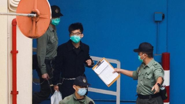 FILE PHOTO: Pro-democracy activist Joshua Wong walks to a prison van to head to court with other activists, over a national security law charge, in Hong Kong, China March 4, 2021. REUTERS/Tyrone Siu/File Photo