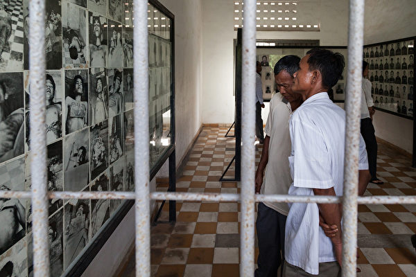 图为参观者在观看博物馆里展示的受难者的照片。(Omar Havana/Getty Images)