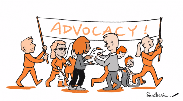 Image shows a group of researchers holding a banner that says “advocacy”. One person is signing up to join and others are walking/wheeling forward.