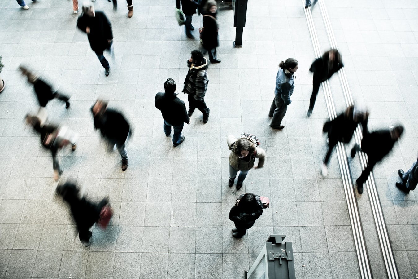 Image of blurred moving people walking through an office lobby