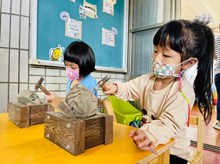  幼生体验正确使用铁槌敲打石头。