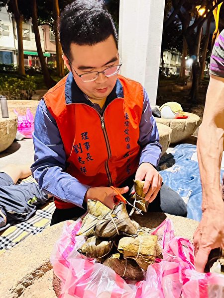 台湾爱的萌芽福利协会理事长刘志枰在街头发放红包及肉粽礼盒。