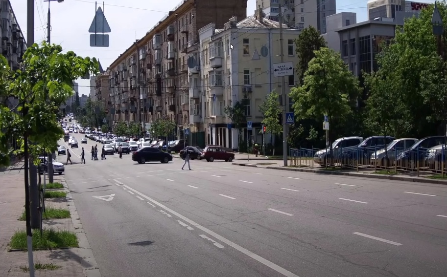 A city street with a car parked on the side of the road