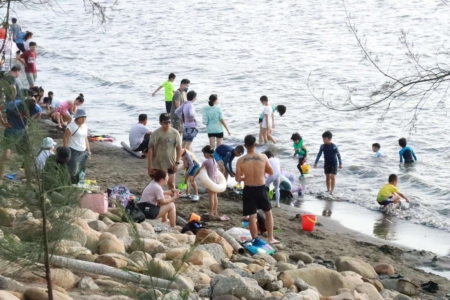 民众在海边戏水。