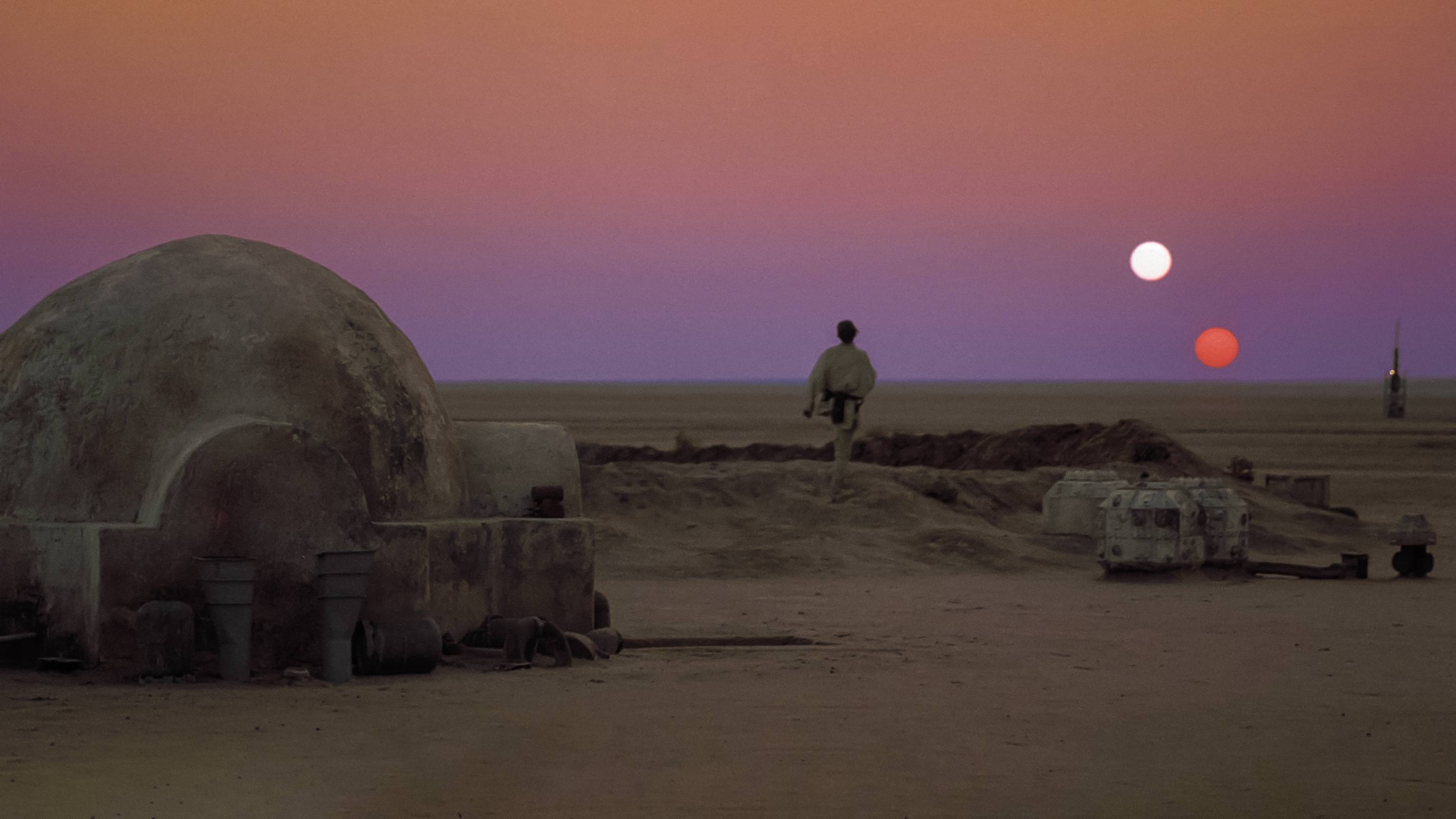 Luke Skywalker looking at the horizon at dusk of the desert planet Tatooine. Two suns are setting in the desolate landscape