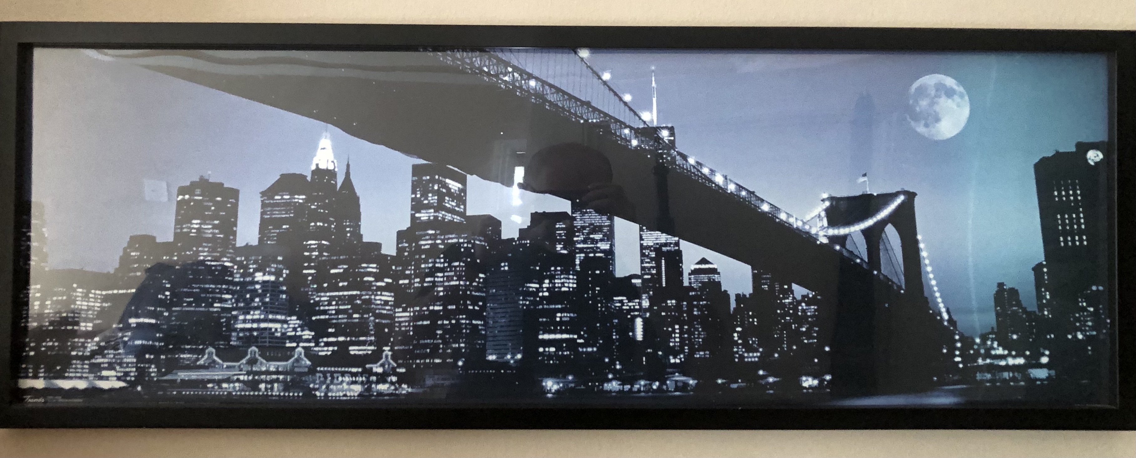 an image of the Brooklyn Bridge with the full moon setting behind it