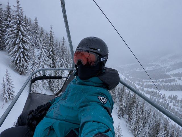On a chairlift above snowy trees
