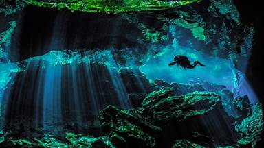 Scuba diver exploring the underwater cenotes near Puerto Aventuras, Mexico (© Extreme Photographer/Getty Images)