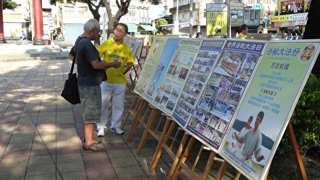 集会现场，屏东法轮功学员透过发送真相资料和真相展板，揭露中共迫害法轮功修炼者手段极其残酷。