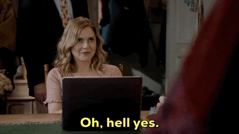 Woman at computer saying 'oh, hell yes'