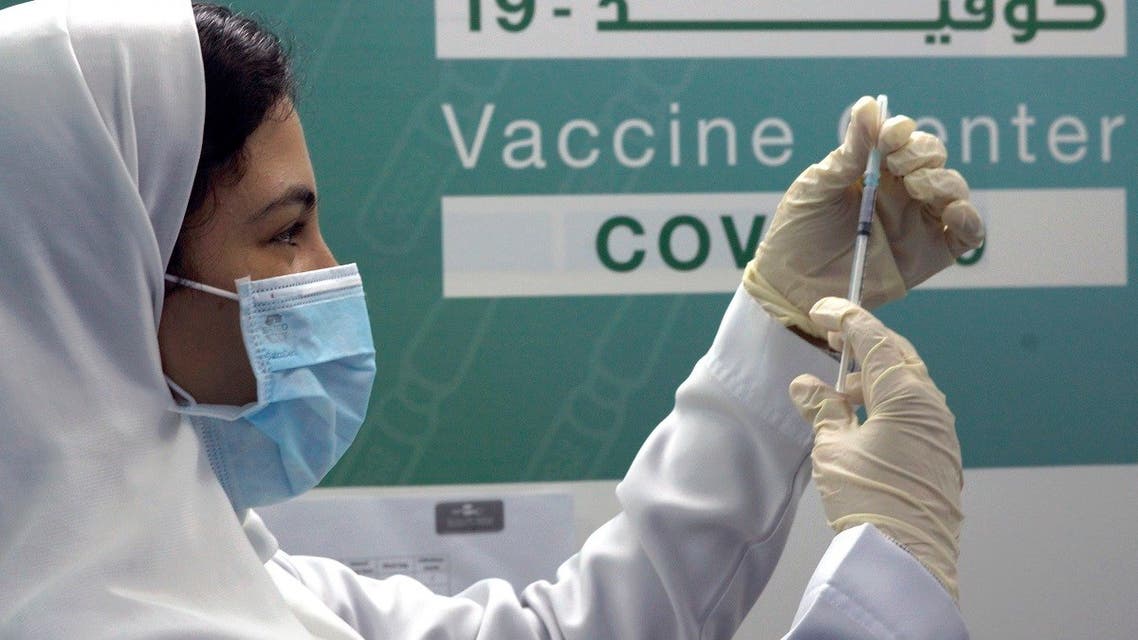 A Saudi physician prepares to inject a Pfizer vaccine at a vaccination center