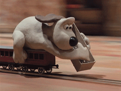 Gromit from 'Wallace and Gromit' frantically lays out train tracks for the mechanical train he is riding atop of to prevent it from running off the rails and crashing