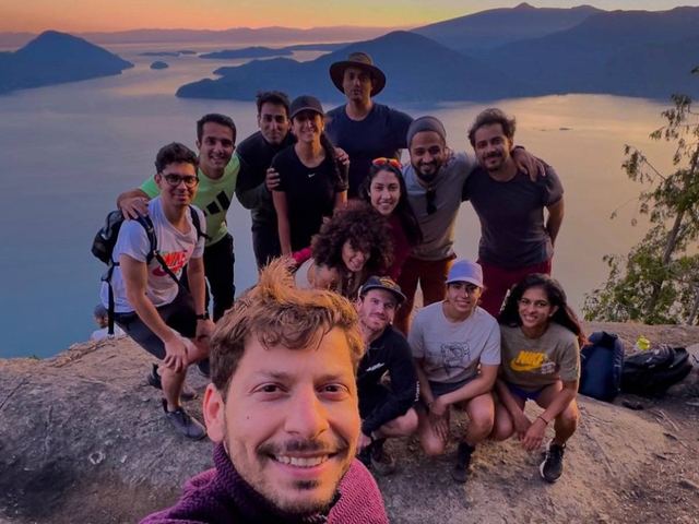 Friends on a mountain summit at sunset
