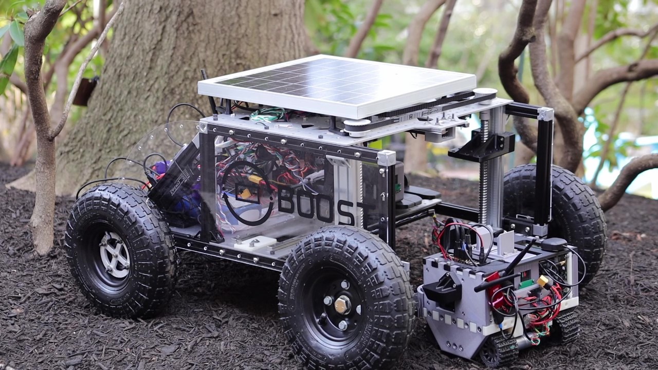 Image of BOOST system, feature hub bot and mini-rover docked in an outdoor field environment.