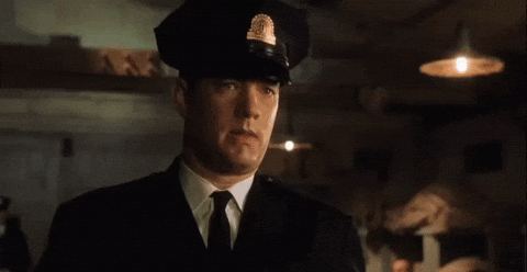 Tom Hanks in a captain's outfit saying 'May God have mercy on my soul'
